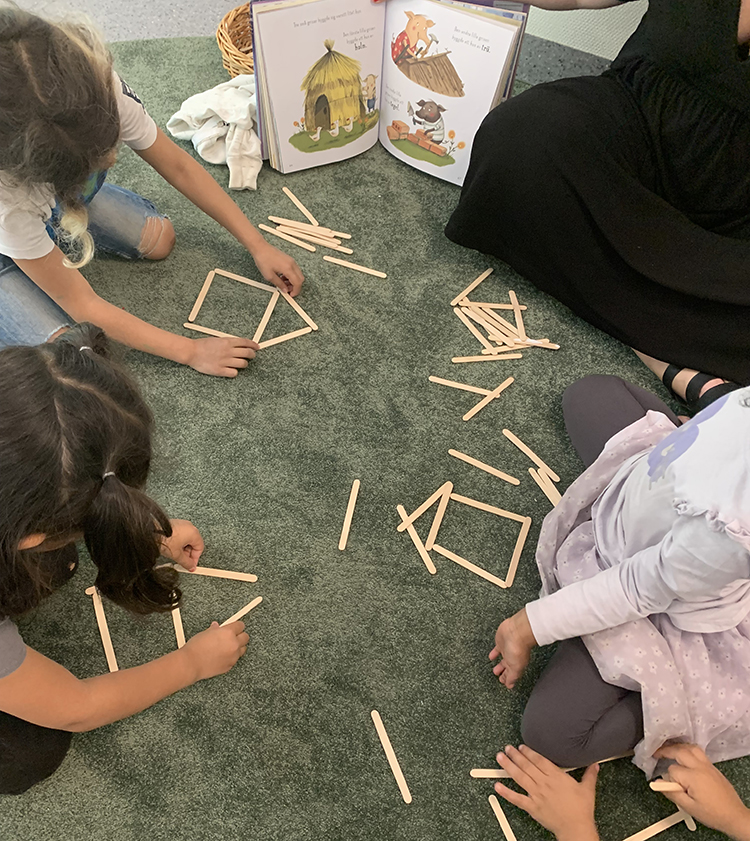 Barnen formar två-dimensionella hus av glasspinnar utifrån sagan om De tre små grisarna