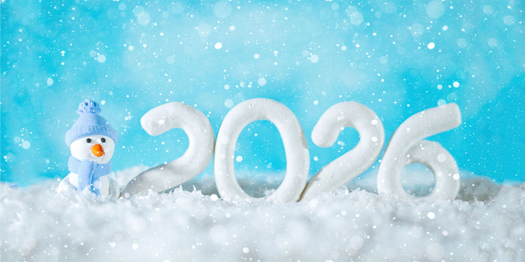 En snögubbe och årtalet 2026 skrivet med snö.