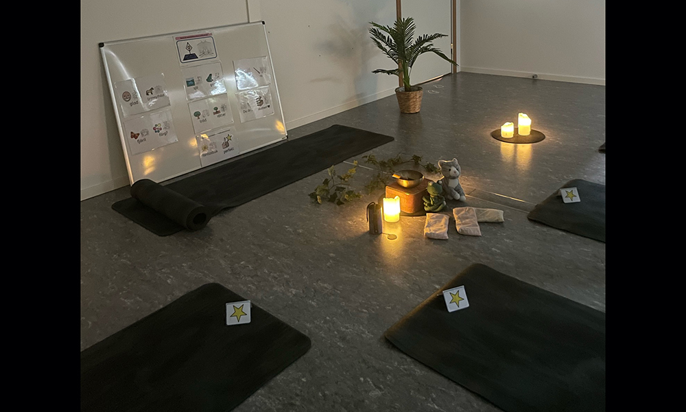Yogarum för barnen med dämpad belysning och yogamattor.