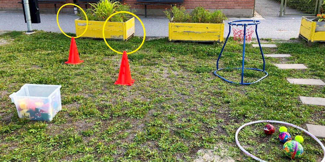 Bollar, rockring och andra aktiverande föremål på en gräsmatta utanför förskolan.