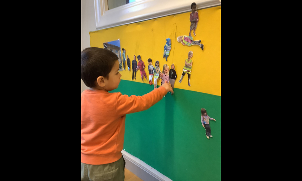 Barn tittar på figurer uppsatta på vägg.