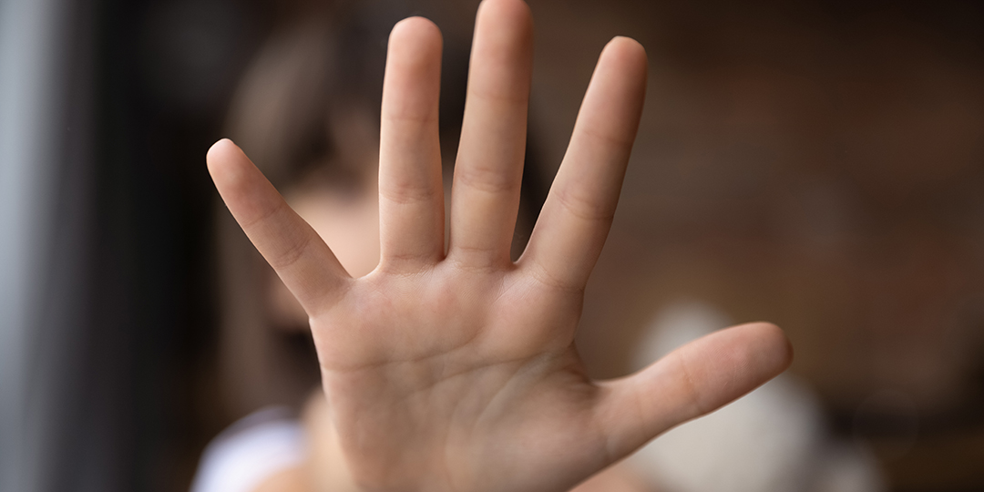 Barnhand som visar stopptecknet.