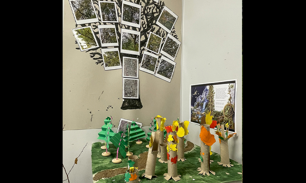 Ett träd med fotografier och pysslade träd som barnen har skapat.