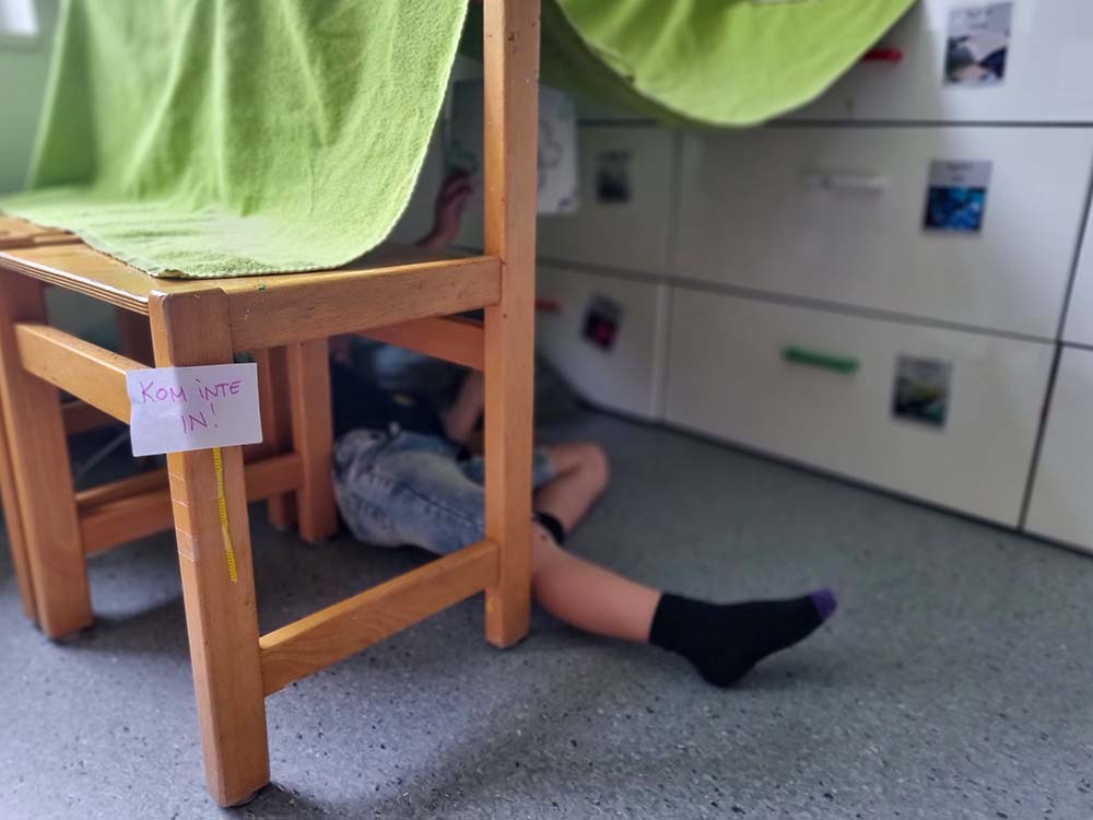 Bild som visar en enkel koja med stolar och filt och en skylt med texten Stör ej.