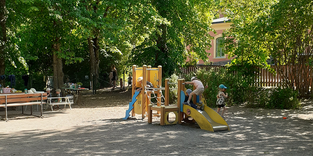 Barn leker på förskolans lummiga gård.