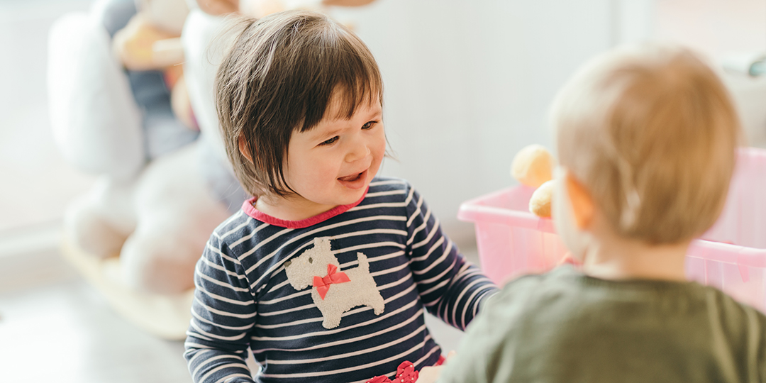 Två små barn som leker tillsammans.