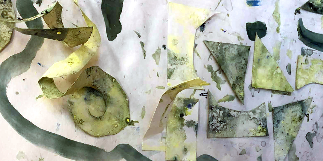 Färglagda utklippta pappbitar arrangerade i ett oregelbundet mönster.