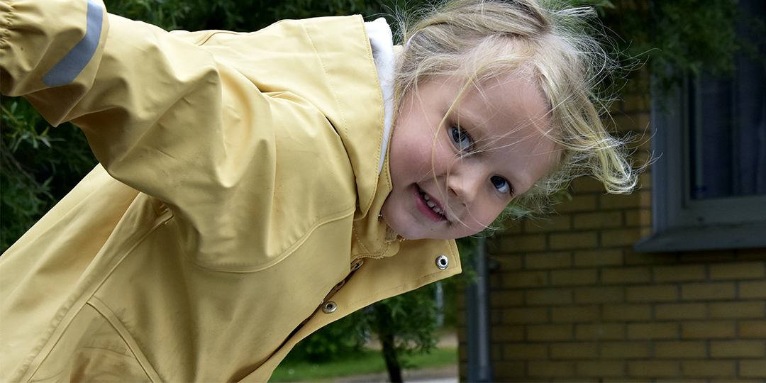 Ett förskolebarn på väg att åka ned för en rutschkana.