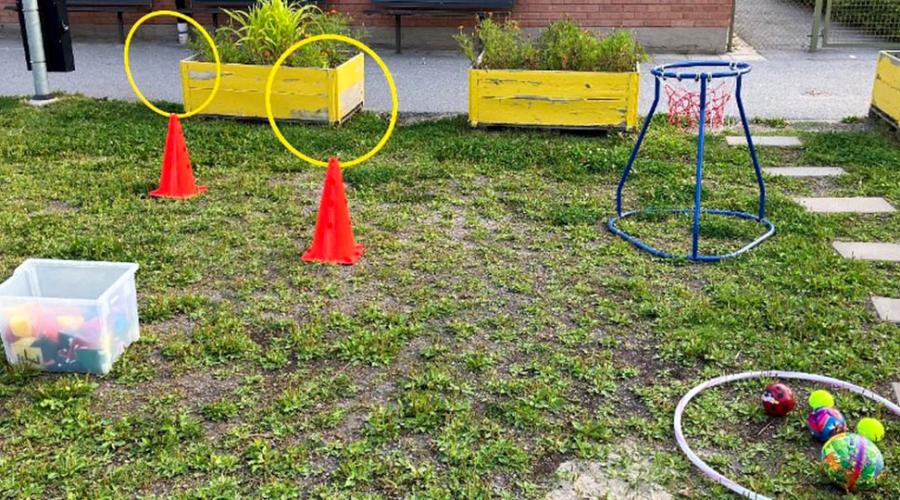 Bollar, rockring och andra aktiverande föremål på en gräsmatta utanför förskolan.