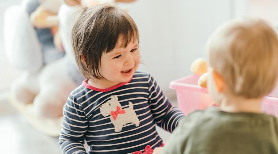Två små barn som leker tillsammans.