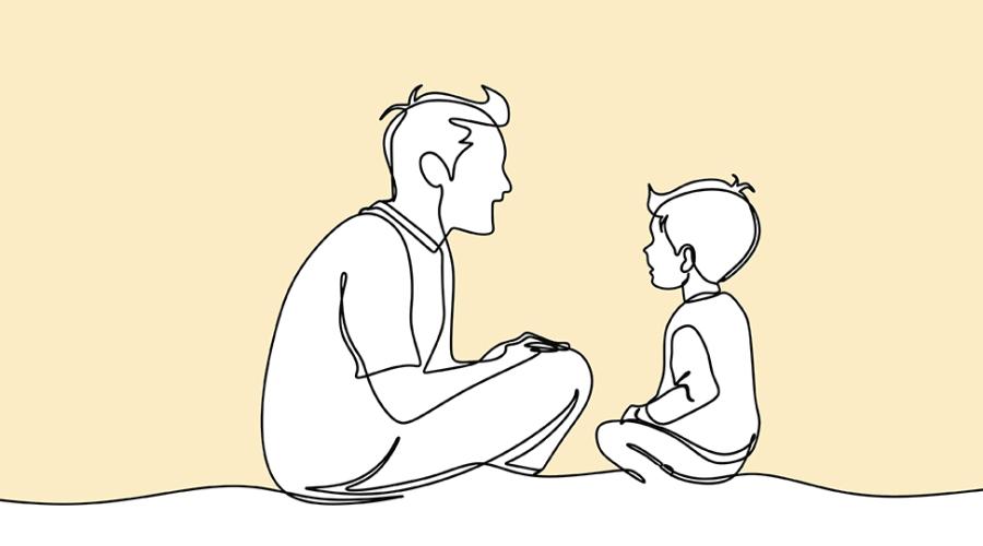En pedagog och ett barn sitter på knä mitt emot varandra.