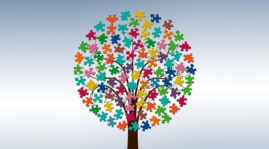 Ett träd med krona av pusselbitar i många olika färger.