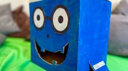 Figuren Ordslukaren är gjord i blå papp och äter korrekta ord.