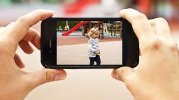 Kvinna filmar barn med mobiltelefon