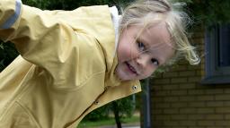 Ett förskolebarn på väg att åka ned för en rutschkana.