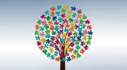 Ett träd med krona av pusselbitar i många olika färger.
