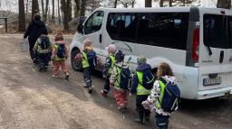 Pedagog och barn på bussutflykt.