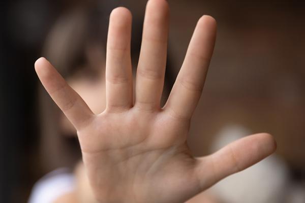 Barnhand som visar stopptecknet.