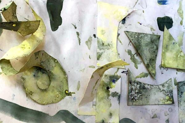 Färglagda utklippta pappbitar arrangerade i ett oregelbundet mönster.