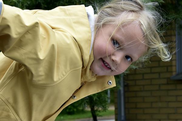 Ett förskolebarn på väg att åka ned för en rutschkana.