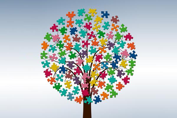 Ett träd med krona av pusselbitar i många olika färger.