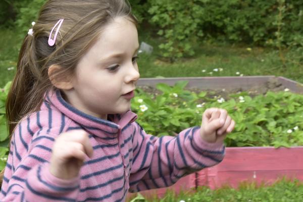 Flicka springer på förskolegården.