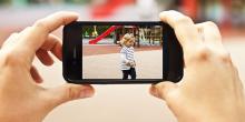 Kvinna filmar barn med mobiltelefon