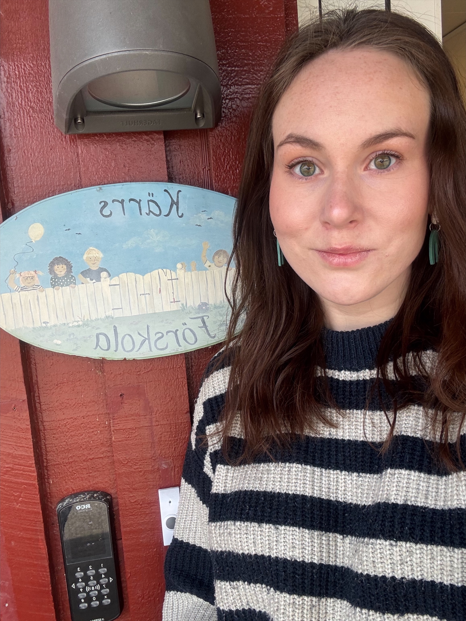 Bild på Mikaela Jakobsson där hon står bredvid skylten till förskolan.